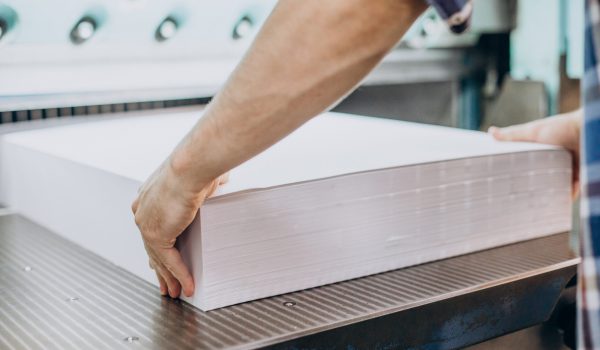 Man working in printing house with paper and paints